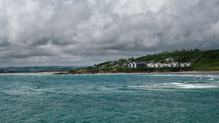 Stunning coastal view of Inchydoney Island in Ireland featuring rolling waves and lush green hills.の写真素材