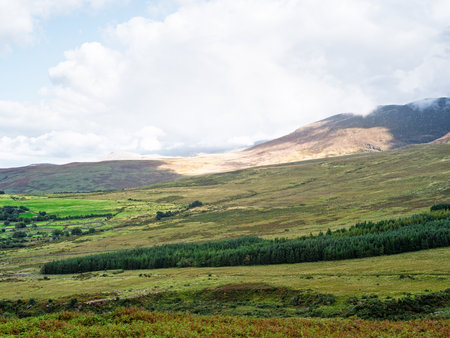 Carrauntoohil walkway offers stunning views of mountains and valleys in county kerry, ireland on a partly cloudy day.の写真素材