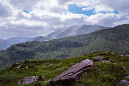 Serene mountain vista. Rolling green hills meet a clear sky. A sense of peace and vastness fills the landscape.の写真素材