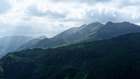 Serene mountain landscape under a cloudy sky. Perfect for travel, nature, or adventure themes.の写真素材