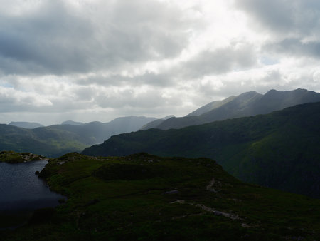 Picturesque mountain scenery featuring a small lake, ideal for travel blogs and tourism.の写真素材