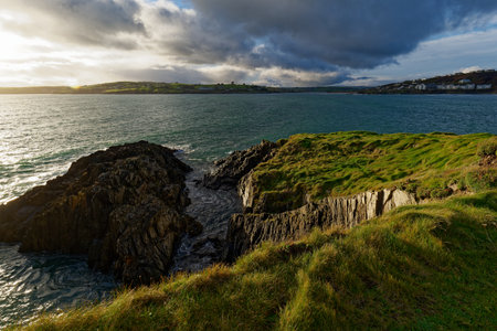 Overlooking the ocean from a grassy cliff in West Cork, Ireland. Waves move around the rock...