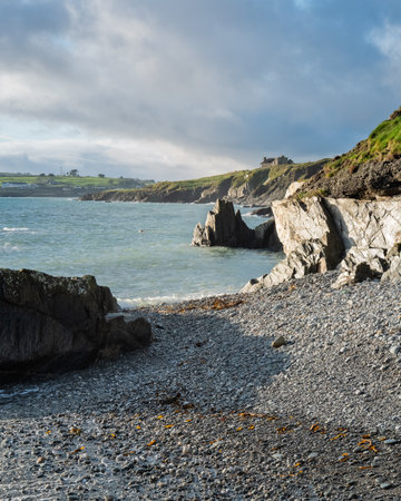 Beautiful Irish seascape featuring rocks, pebbles, grass and blue skies.の写真素材