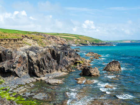 Coastal landscape with rocky formations. Seascape with textured rocks and clear water.