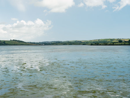 Rolling green hills line the distant shore.の写真素材