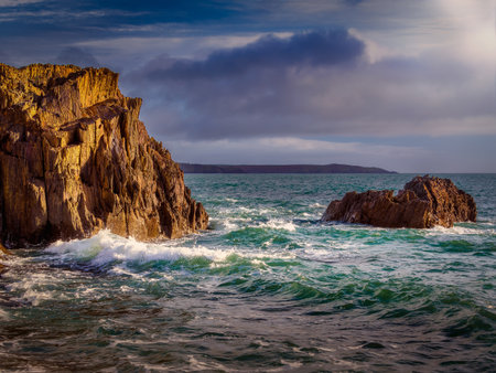 Powerful ocean waves crashing against the rocky coastline.の写真素材