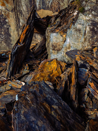 The rough texture of the rock is contrasted by smooth, light reflecting surfaces. The details and layers invite exploration and reflection.の写真素材