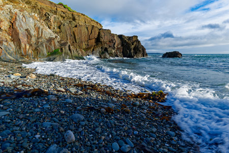 Coastal landscape. Cliff, rocky shore, and ocean waves combine for a dynamic scene.の写真素材