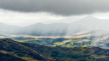 A view of a vast valley in County Kerry, Ireland, bathed in sunlight and clouds.の写真素材