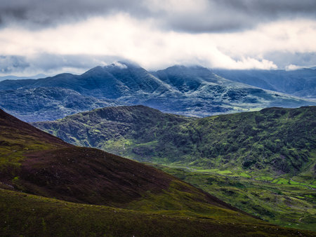 Overcast day on the Coomloughra Horseshoe hiking trail with moody clouds and green hills in Ireland.の写真素材