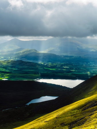 Landscape view of Killarney National Park showing sunlight shining through clouds in County Kerry, Ireland.の写真素材