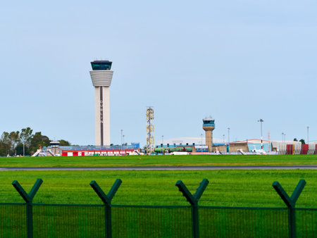 Dublin, Ireland, October 8, 2023. The towering main control tower at Dublin Airport prominently displays the city's name. A smaller, older tower and airport buildings stand behind a green field.のeditorial素材