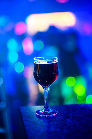 glass of wine at a party on a blue backgroundの写真素材