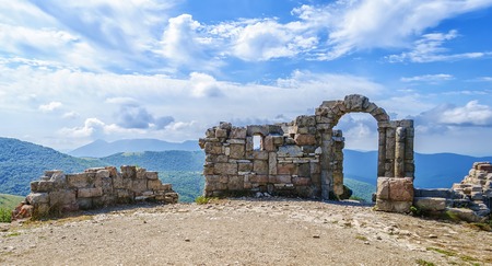 ancient stone gate in the mountains under blue sky in summerの写真素材