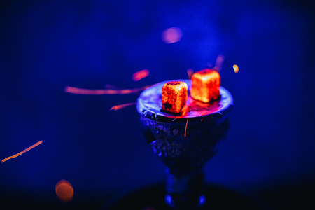 Hot coals on the bowl of the hookah with sparks for a traditional Eastern relaxation and enjoymentの写真素材
