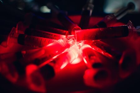 syringes with blood clearance Halloween horrible on a dark background with red lighting and alcoholの写真素材