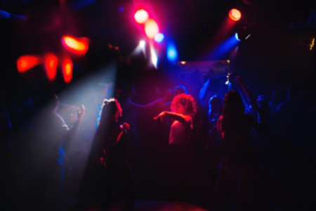 blurred people dancing on the dance floor in a nightclub at a concert partyの写真素材