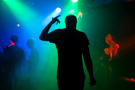 silhouette of presenter on night club stage at concert back at the eventの写真素材