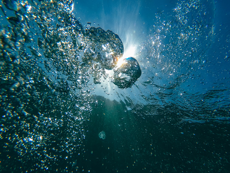 air bubbles at water surface in sea in clear blue waterの写真素材