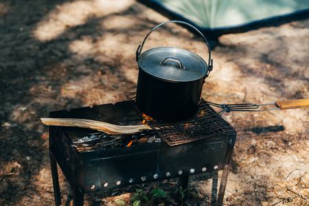 metal pot of food heated on fire camping tripの写真素材