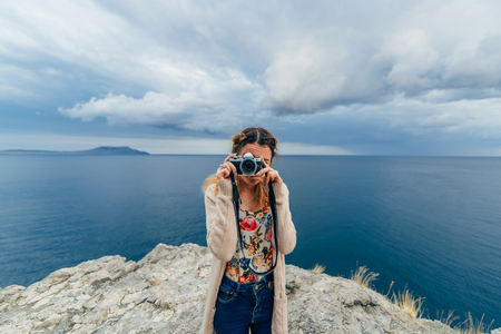 girl taking pictures outdoors on a cameraの写真素材