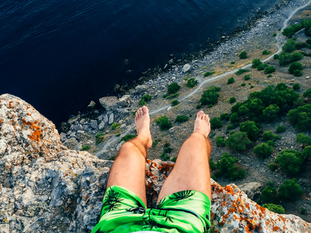 tourist man sitting on top of a mountain over the seaの写真素材