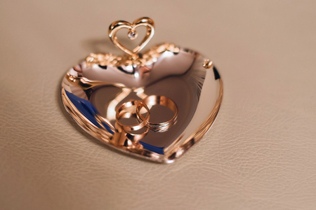 gold traditional wedding rings on a beautiful standの写真素材