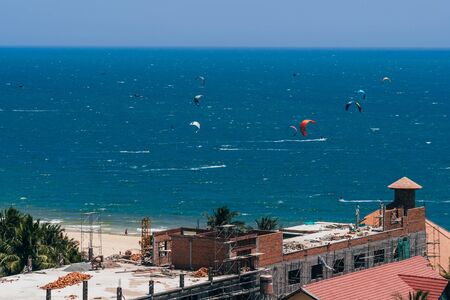 MUI NE, VIETNAM - MARCH 8, 2017: Kitesurfing on the waves of the sea on the beach
