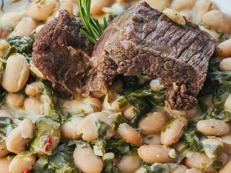 cooked beef in a sauce with beans and rosemaryの写真素材