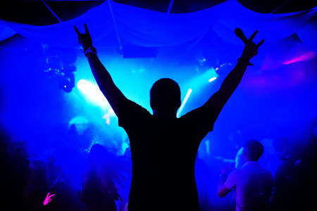 silhouette of a man leading with a microphone on a concert night club