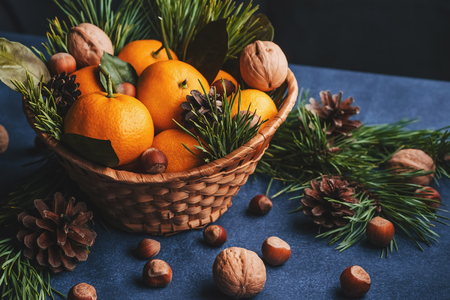 Tangerines, walnuts and hazelnuts decorated with pine cones and branches. Christmas winter decorの写真素材