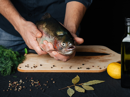 red fish mens hands close-up Board spices. rainbow troutの写真素材