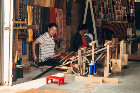 MUI NE, VIETNAM - MARCH 6, 2017: Women weavers work traditional looms for silk