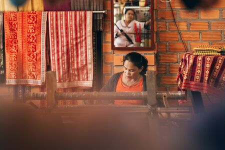 MUI NE, VIETNAM - MARCH 6, 2017: Women weavers work traditional looms for silkのeditorial素材