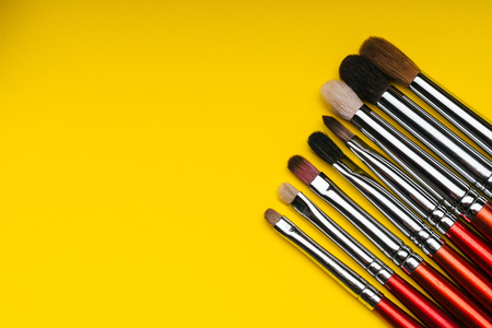 professional set makeup brushes on yellow backgroundの写真素材