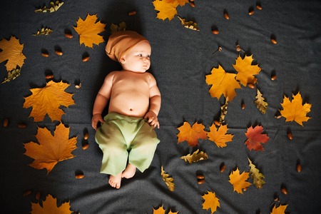 Newborn baby boy lies on autumn backgroundの写真素材