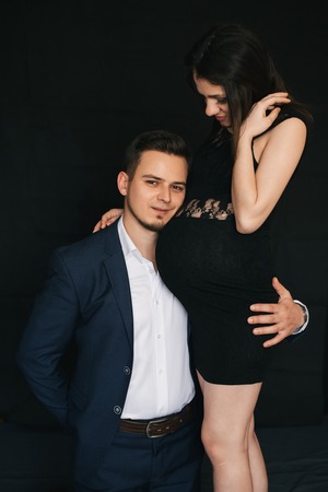 pregnant couple hugging. Lovers fashionable young man and womanの写真素材