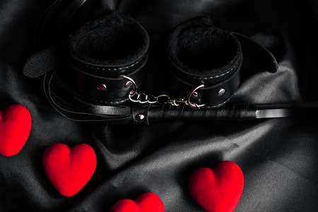 Handcuffs and whip for BDSM sex with red hearts.の写真素材
