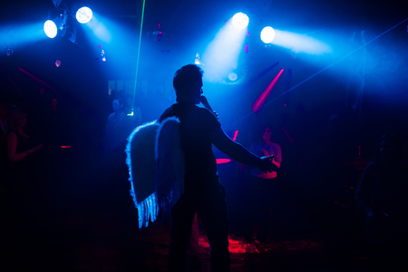 silhouette of the singer at a live concert at the club at the event against the crowdの写真素材
