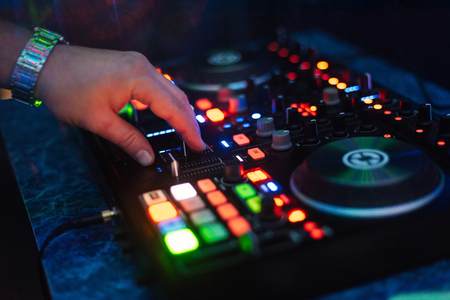 hands DJ playing and mixing music on music controller at a partyの写真素材