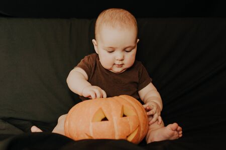 little baby boy sitting with Halloween pumpkin Jackの写真素材