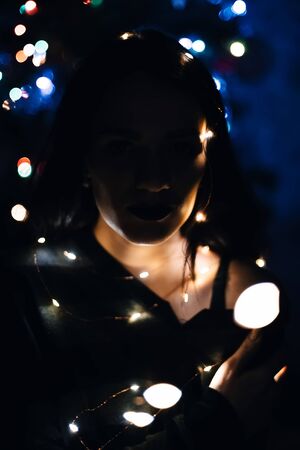 portrait of a girl with a garland with lightsの写真素材