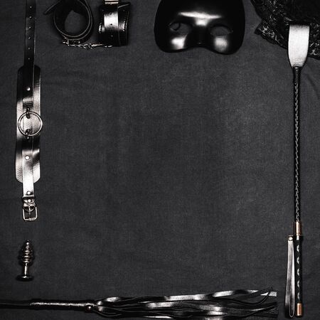 set of sex toys on black background with copy space. Leather whip, handcuffs, choker, mask and metal anal plug for BDSM sexの写真素材