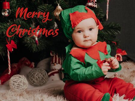 greeting card with a little boy under the tree and the inscription Merry Christmasの写真素材