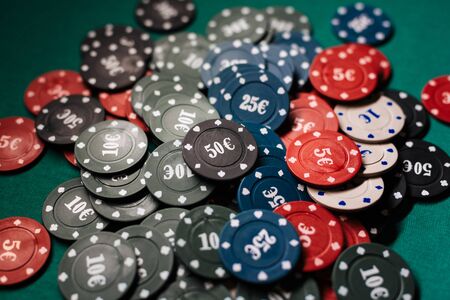 pile of poker chips on a green table close up in a casino