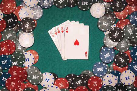Royal flush in a game of poker on the background of a green table with gaming chips