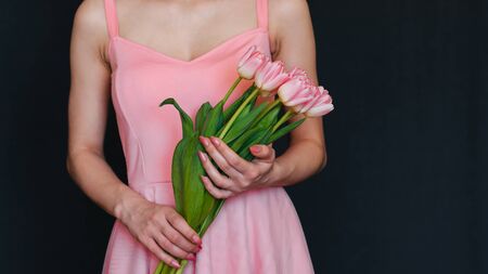 bouquet of pink tulips in the hands of a girlの写真素材