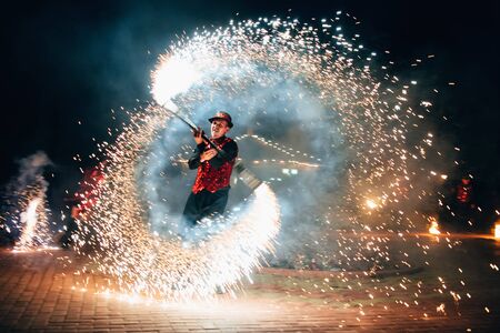 SEMIGORYE, IVANOVO OBLAST, RUSSIA - JUNE 26, 2018: Fire show. A man spins a fire sparkling torchesのeditorial素材