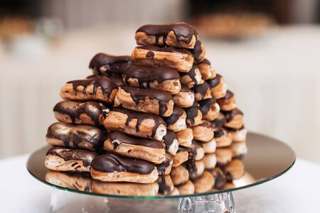 delicious sweet eclairs with chocolate cream and whipped cream insideの写真素材