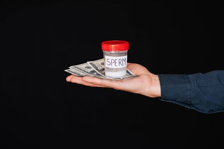 Bank of sperm and money in the hand of a manの写真素材